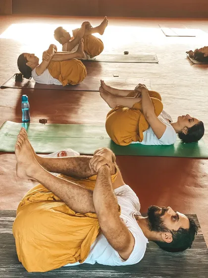 This is a duplicate of image 51. Students relax in Apanasana, a key posture for spinal health and relaxation.