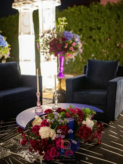 A cozy seating arrangement with plush navy armchairs and a crescent moon table. The outdoor heater ensures guests stay warm while enjoying the celestial ambiance.