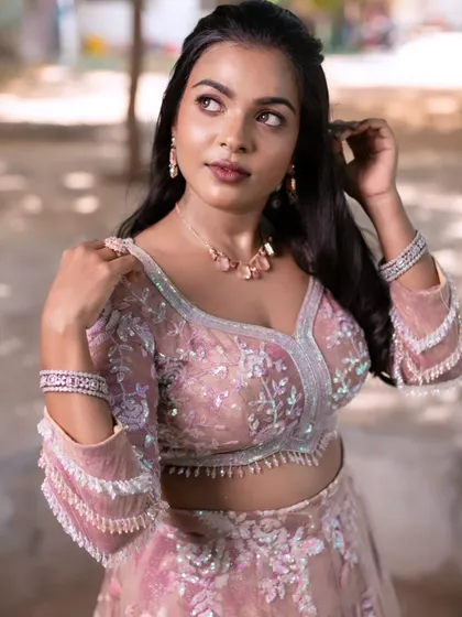 A model posing in a beautiful pink lehenga, perfect for reception style inspiration. The makeup is kept soft and glowing.