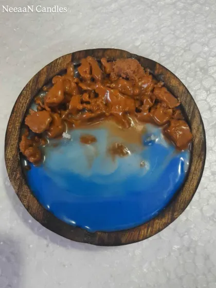 Drift away to the shore with this beach vibe candle. Set in a wooden bowl, it captures the ocean with blue wax and a sandy shore made of wax crumbles.