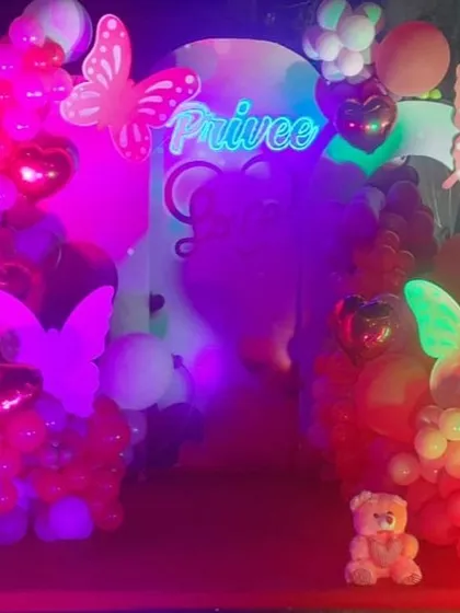 A vibrant and romantic Valentine's Day setup with neon butterflies and heart-shaped balloons, creating a magical and colorful atmosphere.