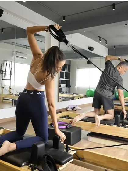 A dynamic shot of a group class, where clients use the reformer to build strength and improve alignment, all while being supported by our trainers.