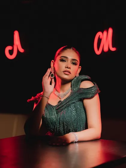 A full view of the look in a moody, lounge setting. This makeup is designed to make a statement.