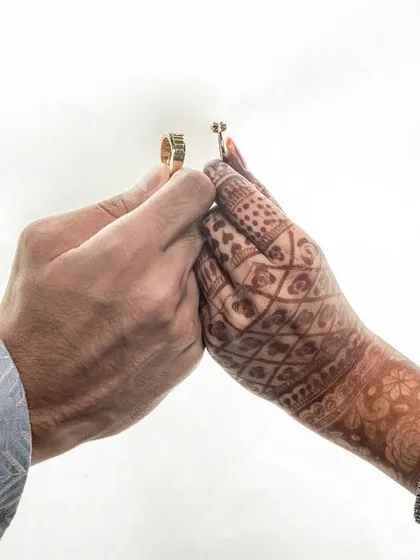 A close-up shot of the couple's hands as they exchange rings, a powerful symbol of their commitment.
