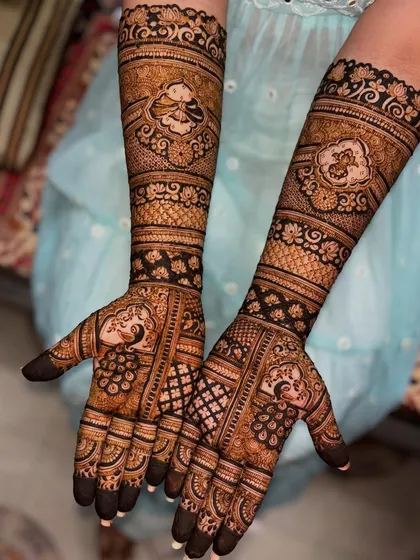 A closer look at a bridal design with peacocks and lotus motifs. The dark henna paste ensures a beautiful stain, which is crucial for wedding photography.