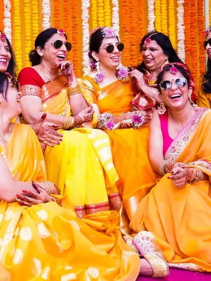 The bride tribe having a blast. The matching sunglasses and coordinated laughter make this a fun and memorable group shot from the Haldi.