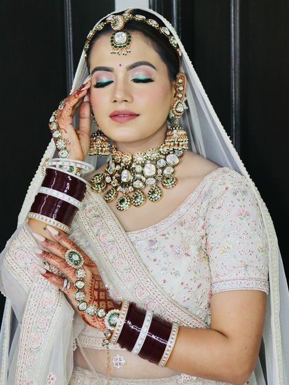 The bride showcasing her hands, adorned with beautiful mehndi and nail art.