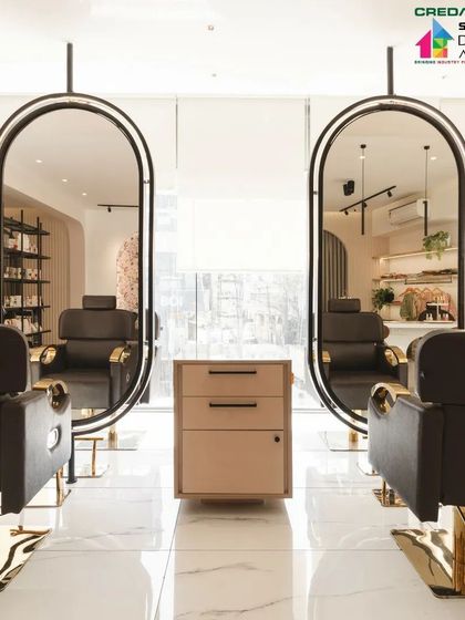 Custom-designed styling stations at 'Frumos' salon. The suspended, black-framed oval mirrors are a key feature, adding a touch of modern elegance and creating a sense of lightness in the space.