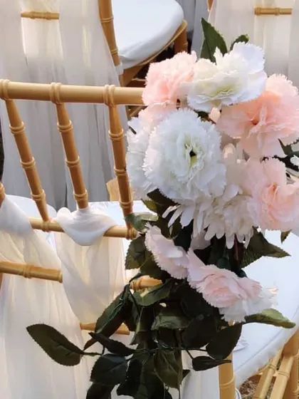 A close-up of the floral arrangement tied to a guest chair. We used a lovely bouquet of white and blush pink carnations to complement the event's color palette.