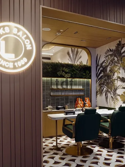 The nail art and pedicure section of the salon continues the biophilic theme. The illuminated brand signage and curated greenery create an inviting entrance to this specialized zone, ensuring a cohesive design experience throughout the space.