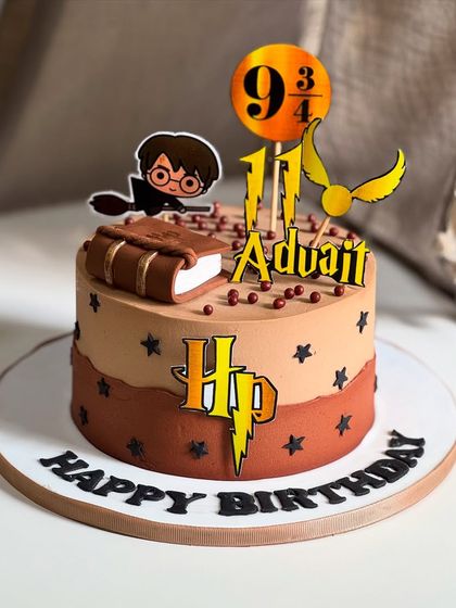 A magical cake for a Potterhead! This Harry Potter themed cake features the iconic HP logo, a golden snitch, and a spellbook, all crafted with minimal fondant for a clean yet enchanting look.