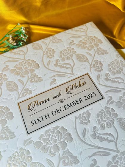 A close-up shot of the embossed texture. The raised floral pattern on premium paper creates a sense of classic luxury and meticulous craftsmanship.