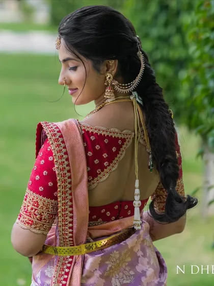 A statement back can transform an entire outfit. For this bride, I created a custom red raw silk blouse with intricate zari and zardosi embroidery, featuring a unique back design that perfectly complements her lavender Kanchivaram saree.