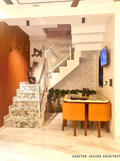 Even small corners can be made functional and stylish. I designed this compact chess table nook under the stairs, using vibrant orange chairs to add a pop of color to the space.