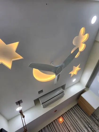 A creative false ceiling design with backlit stars, a moon, and a cloud, making the room feel magical.