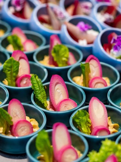 Artistry on a plate from our Summer Cooler Brunch. These small bowls contain a beautifully arranged salad with pickled radish and fresh greens, showcasing our commitment to presentation and fresh, seasonal ingredients.
