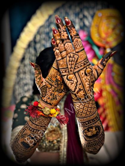 A classic bridal pose showing the rich stain of a detailed wedding mehndi. The design features traditional elements perfect for a wedding ceremony.