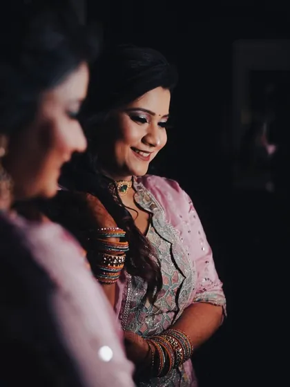 A creative shot of the bride looking at her reflection. This introspective moment is captured with beautiful lighting, adding depth and emotion to the wedding album.
