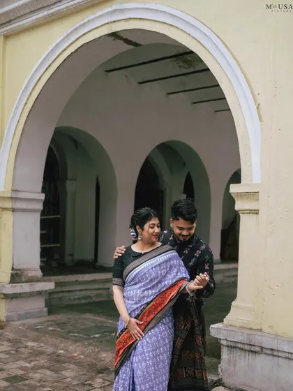 A playful, dancing moment captured within the arched hallways of a vintage Sambalpuri structure. This shot shows the joy and comfort they find in each other's arms.