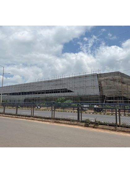 A view of the sports center from the road during construction. Even in its unfinished state, the building's powerful monolithic form is evident.