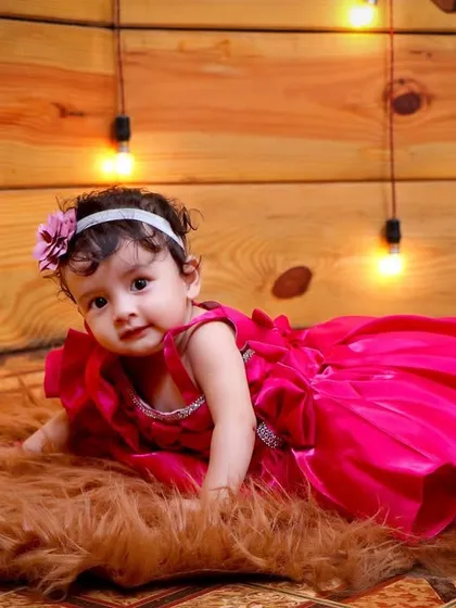 This is from a milestone session, perfect for when babies can sit up and show off their personality. I used a warm, wood-paneled backdrop with string lights and a soft fur rug to create a cozy setting for this baby girl's portrait.