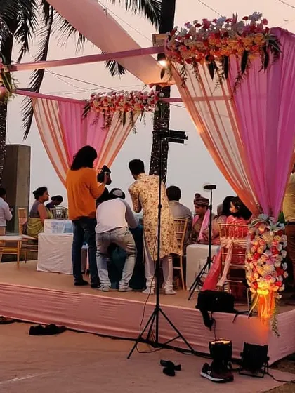 A closer look at a beachside vidhi ceremony stage we designed. The mandap is draped in shades of pink and peach fabric with floral accents, providing a beautiful setting for the couple's rituals against the backdrop of the ocean.