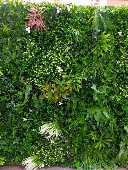 A close-up view of the detail in our premium artificial vertical gardens. We layer various types of faux ferns, ivy, and flowering sprigs to achieve a realistic, three-dimensional texture that looks natural even upon close inspection.