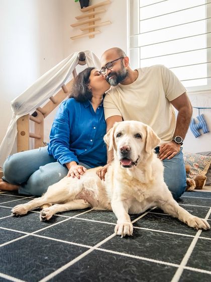 A loving portrait of a couple with their 10-year-old senior Labrador, Shelby. This photo captures the deep bond they share, with Shelby as the heart of their family.