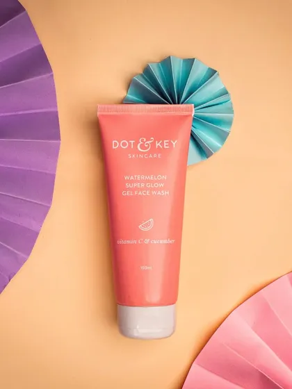 A watermelon face wash styled with colorful paper fans. The bright, complementary colors and simple props create a fun and graphic image that stands out.