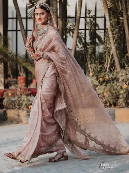 A bride in motion. Namita looks effortlessly graceful as she walks in her stunning pastel saree, the flowing fabric creating a beautiful sense of movement.
