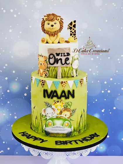 A clean studio shot of the two-tier "Wild One" cake, highlighting the hand-painted details and the cute lion topper.