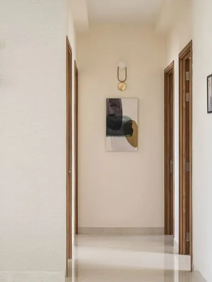 Corridors don't have to be boring. We transformed this simple passage in Project 38 into an elegant hallway by using textured wallpaper, a piece of abstract art, and two distinct, sculptural wall lights that act as focal points.