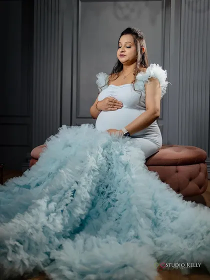 A serene and beautiful shot of the client in her light blue maternity gown. The makeup is soft and glowing, enhancing her peaceful expression.