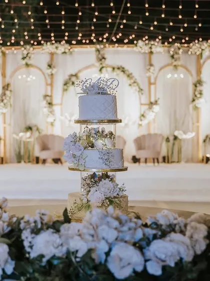 A stunning multi-tiered wedding cake takes center stage in front of an elegant white and gold backdrop. I work with your vendors to ensure every element is perfectly highlighted.