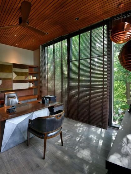 The large windows of the T House study can be covered with wooden blinds, allowing for control over the light and mood of the space.