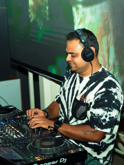 A candid shot of me at work, mixing tracks with the VJ screen in the background. This captures the dual role of being both a DJ and a VJ during a set.
