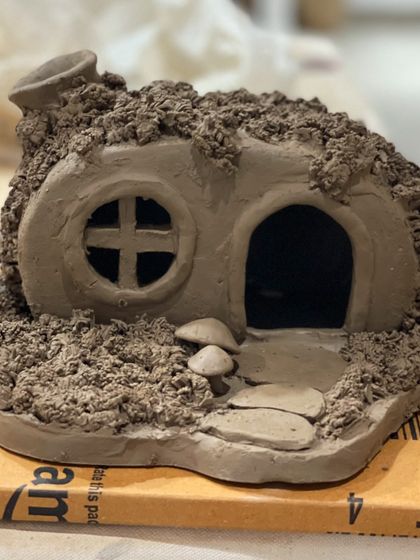 A whimsical fairy house sculpted from clay. This piece shows the incredible imagination and detail that our artists put into their three-dimensional creations.