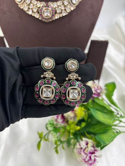 A close-up look at the fine detailing on this Moissanite and Kundan choker. The combination of large uncut stones with a ruby and emerald green center makes it a classic and highly sought-after design.