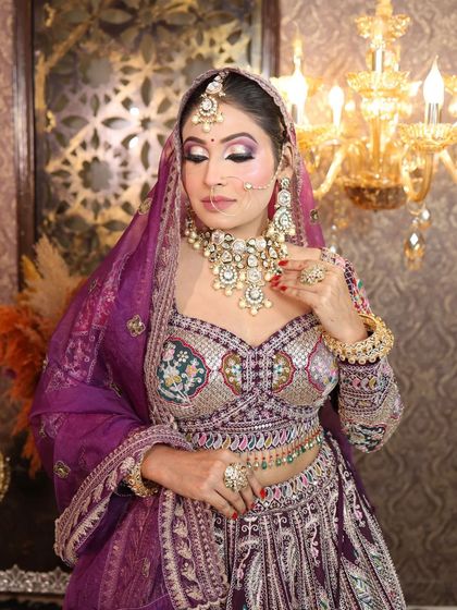A close-up of the purple paisley lehenga, showing the detailed embroidery on the blouse.