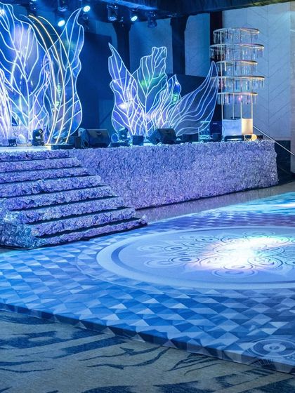A detail of the custom-printed dance floor in front of the Sangeet stage. The geometric and mandala-inspired patterns are illuminated by the stage lights, adding another layer of visual interest.