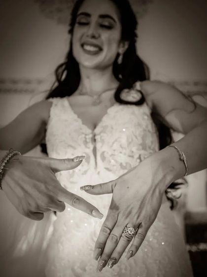 A fun black and white shot of a bride showing off her engagement ring.