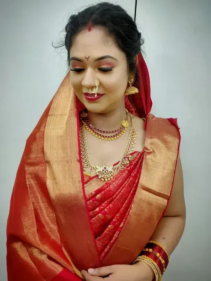 This image highlights the classic South Indian bridal aesthetic, with an emphasis on radiant skin and traditional gold jewelry.