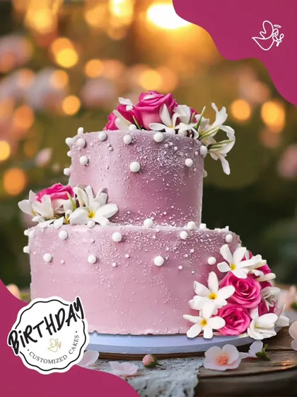 A stunning two-tier cake in a dusty rose color, adorned with fresh flowers and pearls. This sophisticated design is perfect for an elegant birthday or anniversary.