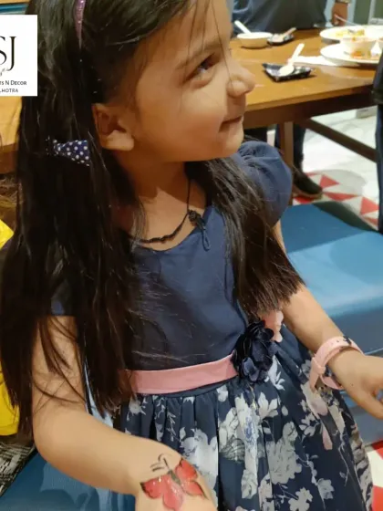 A young guest proudly showing her beautiful butterfly tattoo. It's these small, happy moments that make a party truly memorable.