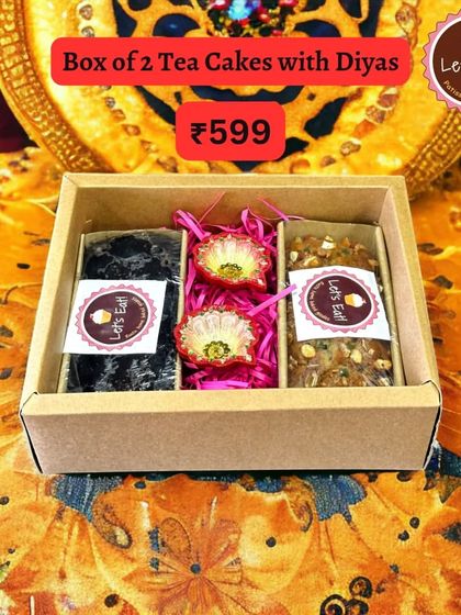 A closer look at the box of two tea cakes with diyas, highlighting the rich texture of the cakes and the intricate design of the diyas.