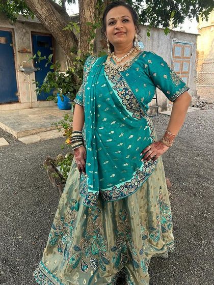 A client looking elegant in a green and gold lehenga, perfect for a traditional function.