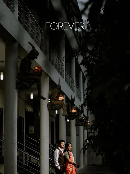 A romantic night portrait of the couple at their reception, standing together under the word "Forever."