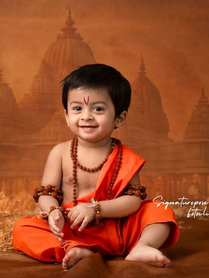 A happy and content little Rama, seated amidst a setting that evokes the ancient city of Ayodhya.