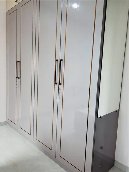 Another angle of the grey wardrobe, showing its seamless integration with the attached dressing mirror and drawers.