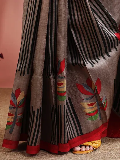 A detailed shot of the saree's border and the colorful floral print, showcasing the fine craftsmanship.